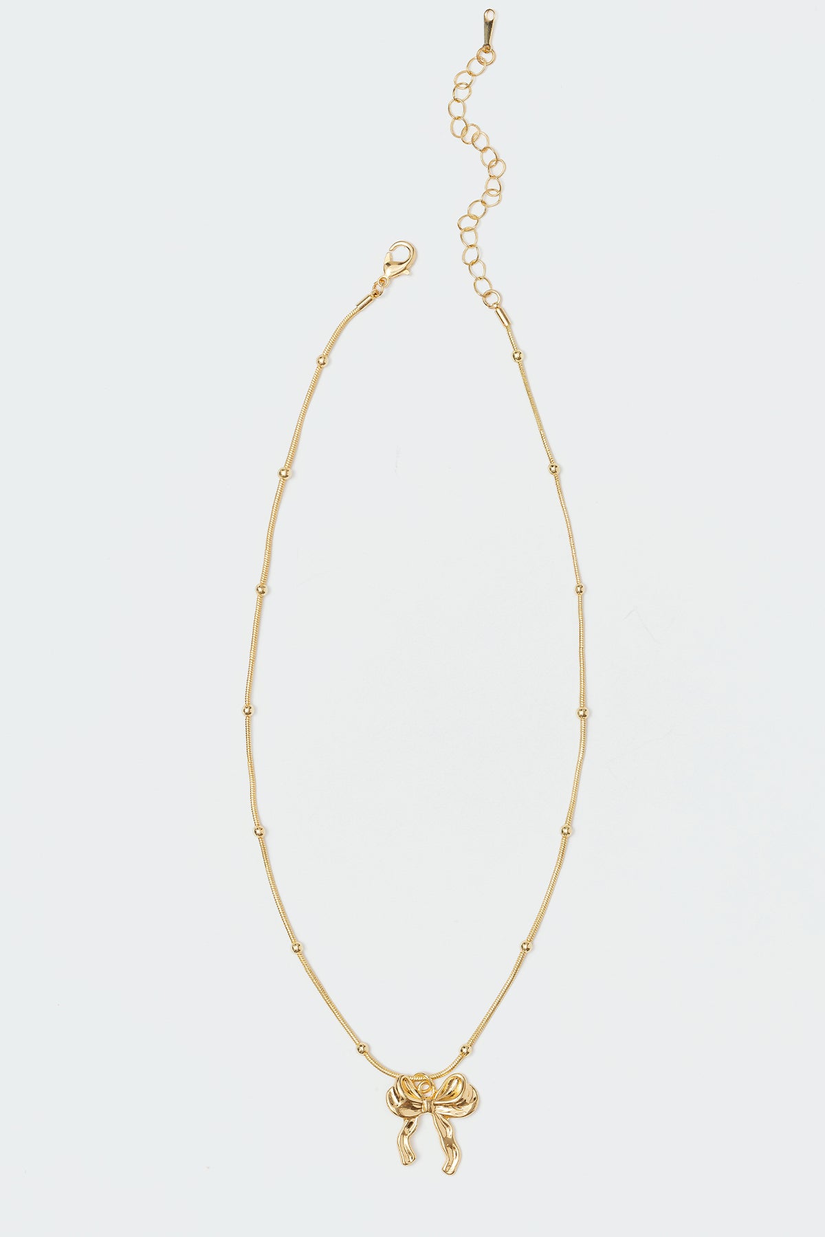 Bow Detail Pendant Necklace in Gold Tone Metal